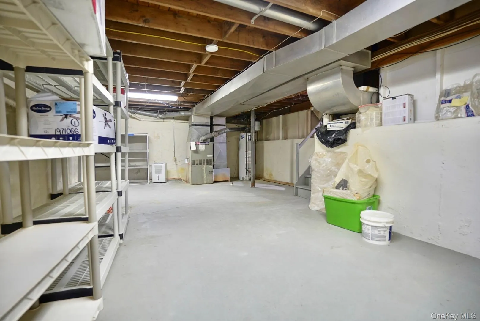 Unfinished below grade area featuring heating unit and water heater Unfinished below grade area featuring heating unit and water heater