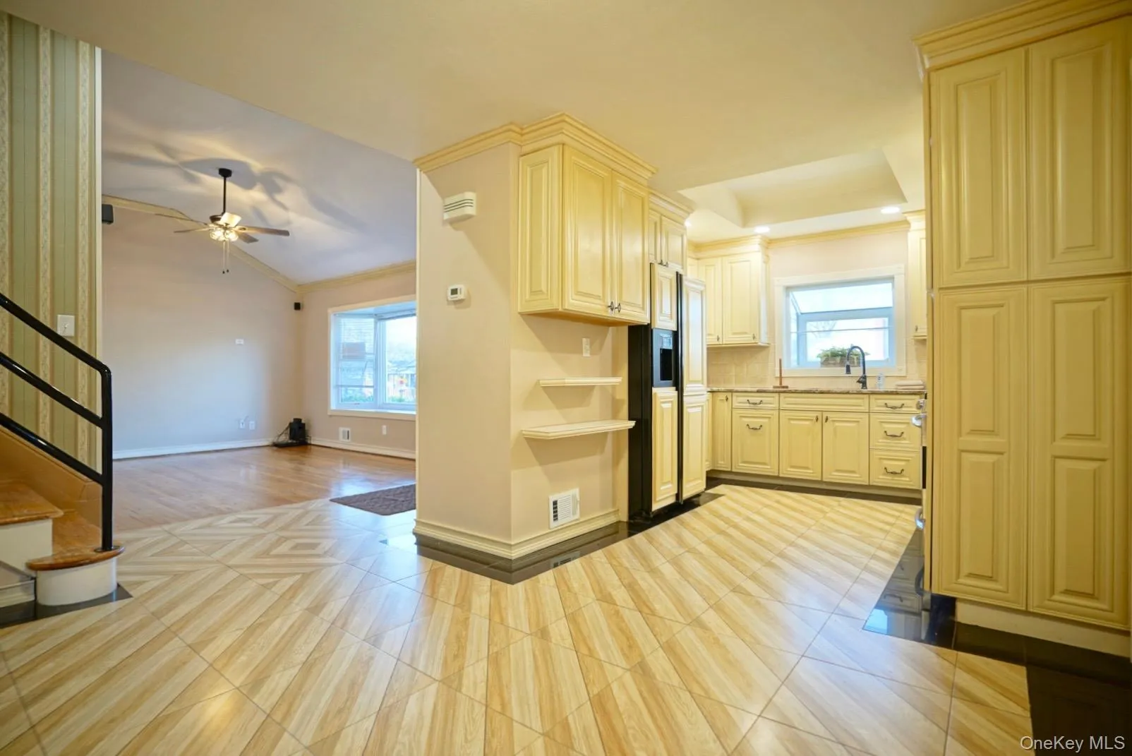 Kitchen with plenty of natural light, paneled fridge, crown molding, open shelves, and open floor plan Kitchen with plenty of natural light, paneled fridge, crown molding, open shelves, and open floor plan