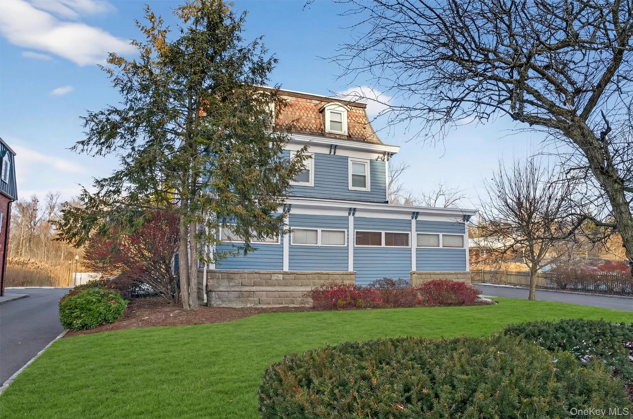 View of property exterior with a yard and mansard roof View of property exterior with a yard and mansard roof