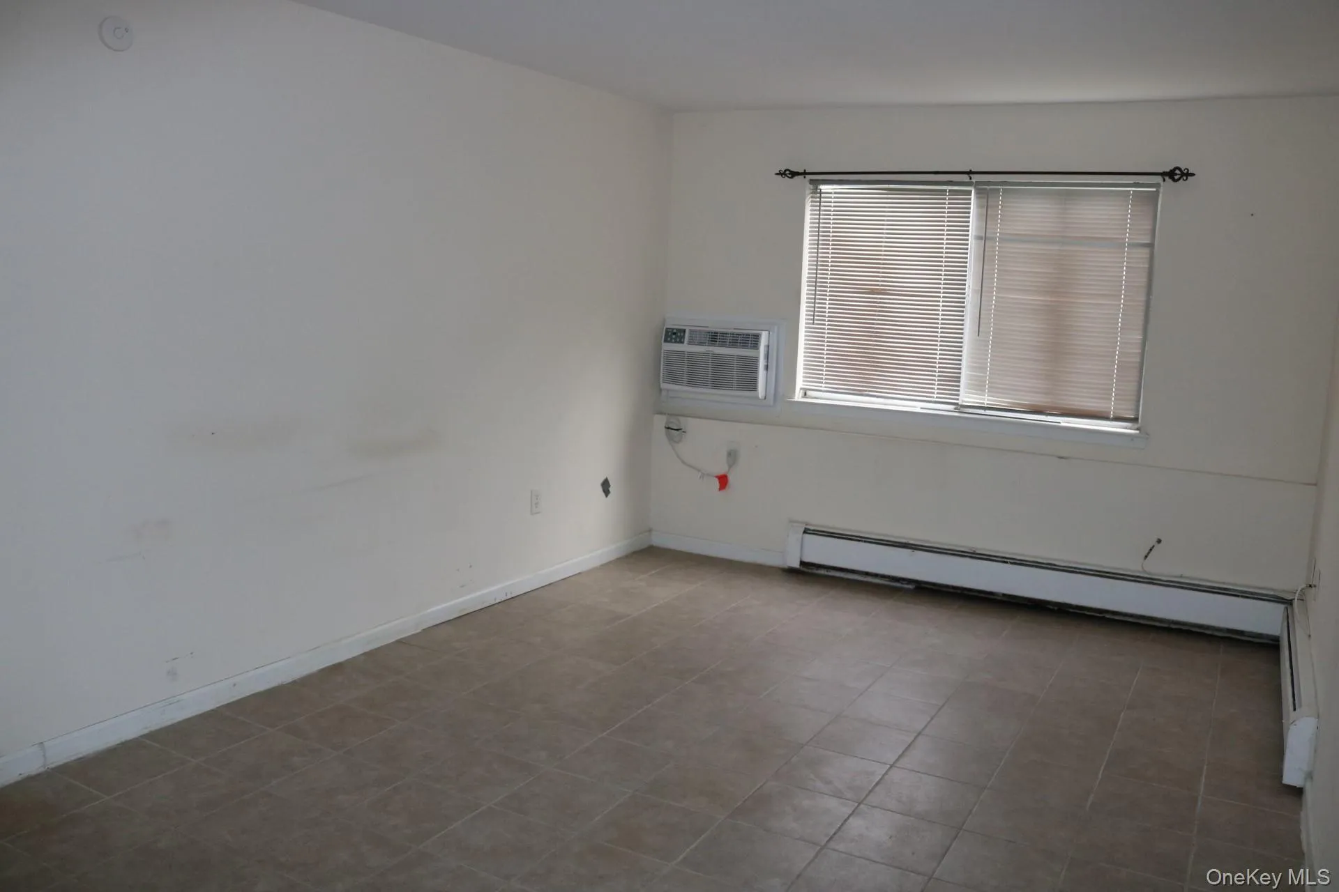 Unfurnished room featuring an AC wall unit and a baseboard radiator Unfurnished room featuring an AC wall unit and a baseboard radiator
