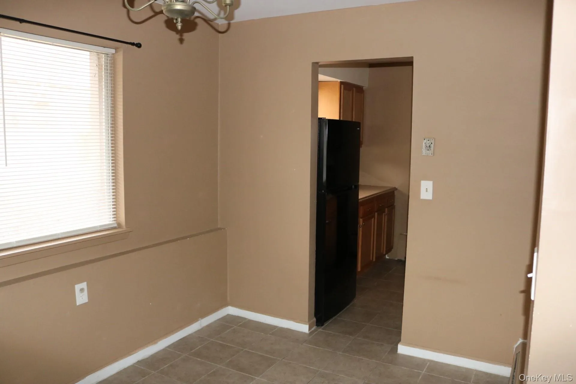 Spare room with an inviting chandelier and plenty of natural light Spare room with an inviting chandelier and plenty of natural light