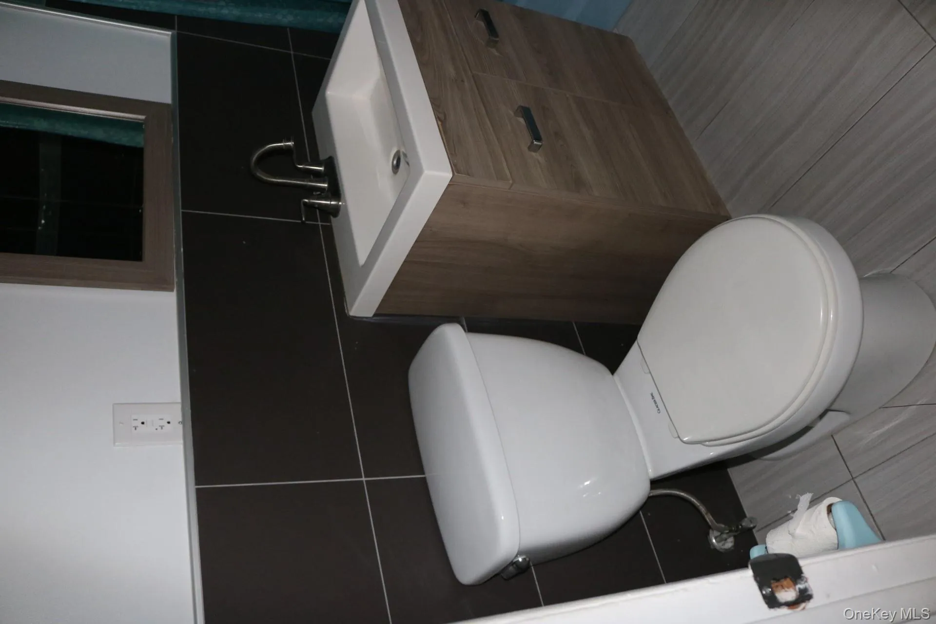 Bathroom featuring vanity, toilet, backsplash, and tile walls Bathroom featuring vanity, toilet, backsplash, and tile walls