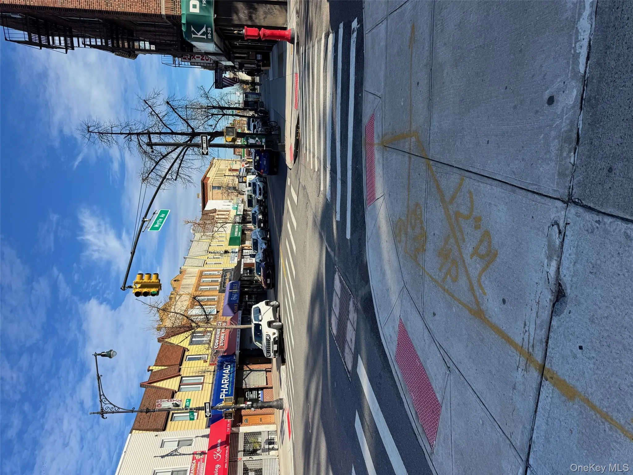 View of asphalt street with sidewalks, traffic lights, curbs, and street lighting View of asphalt street with sidewalks, traffic lights, curbs, and street lighting