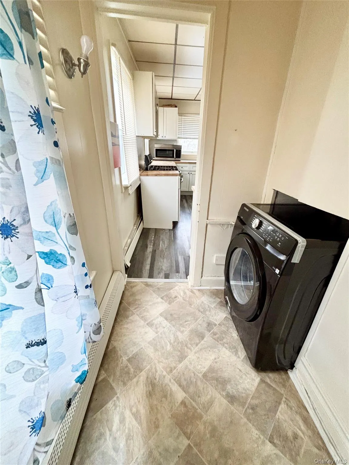 Washroom featuring washer / dryer and a baseboard radiator Washroom featuring washer / dryer and a baseboard radiator