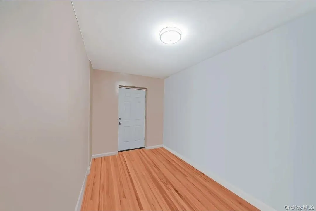 Spare room with wood finished floors and baseboards Spare room with wood finished floors and baseboards