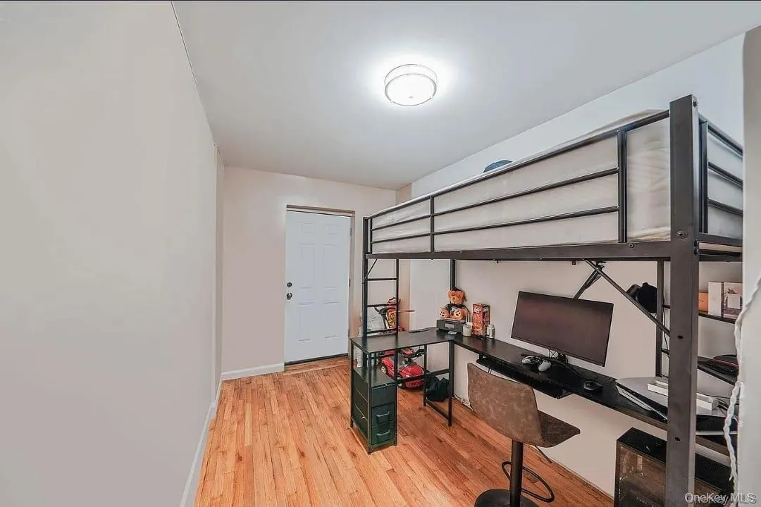 Bedroom featuring light wood-style floors and a desk Bedroom featuring light wood-style floors and a desk