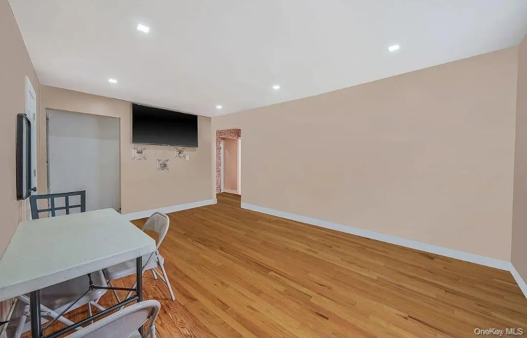 Office space with light wood-style floors and recessed lighting Office space with light wood-style floors and recessed lighting