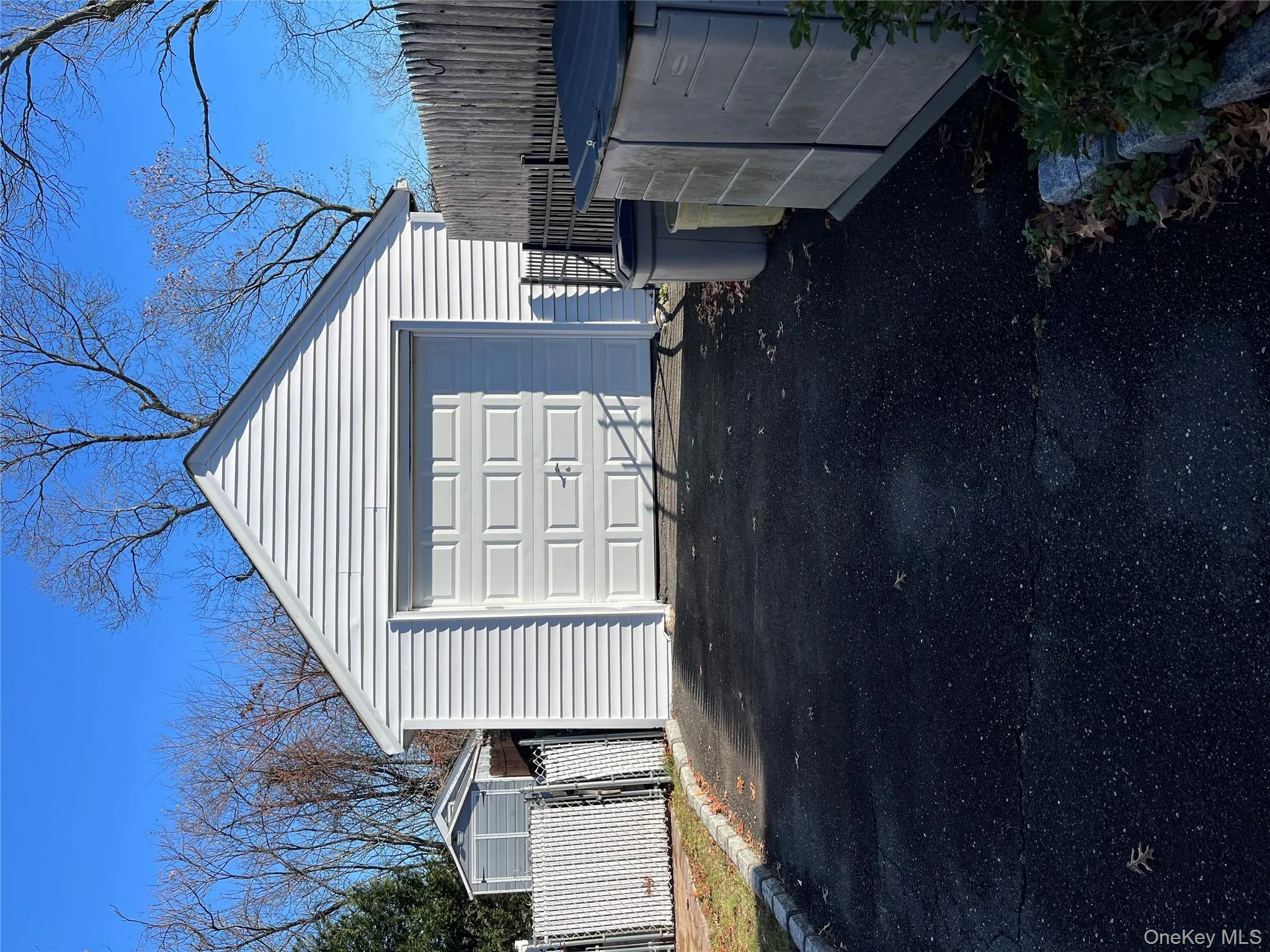 Detached garage featuring asphalt driveway Detached garage featuring asphalt driveway