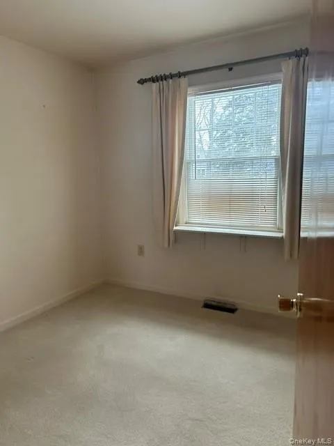 Unfurnished room featuring light carpet and baseboards Unfurnished room featuring light carpet and baseboards