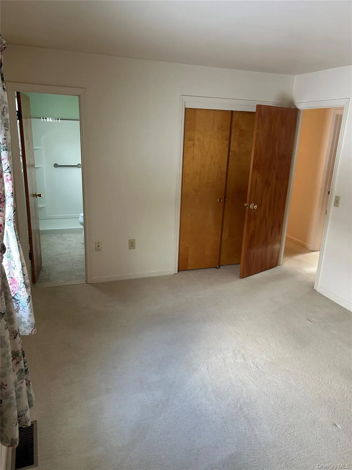 Unfurnished bedroom with light colored carpet and a closet Unfurnished bedroom with light colored carpet and a closet