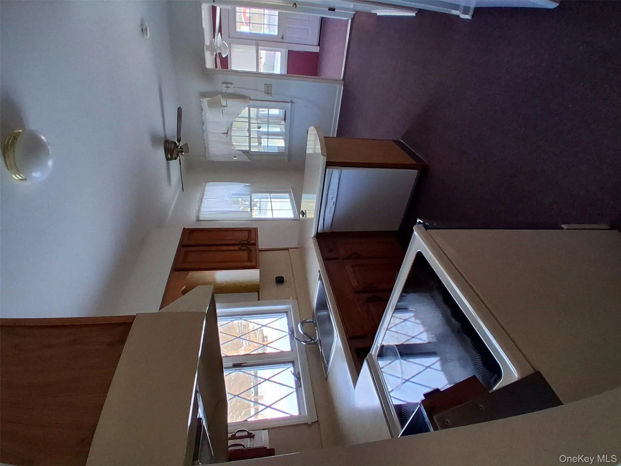 Kitchen with light countertops, a peninsula, stove, brown cabinetry, and stainless steel dishwasher Kitchen with light countertops, a peninsula, stove, brown cabinetry, and stainless steel dishwasher