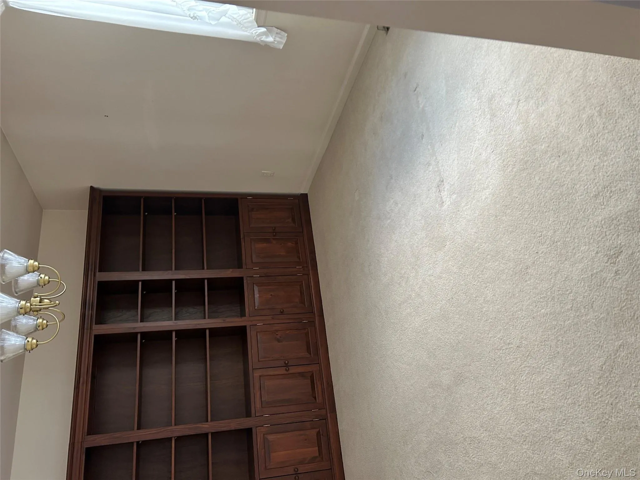 Empty room with light carpet and a chandelier Empty room with light carpet and a chandelier