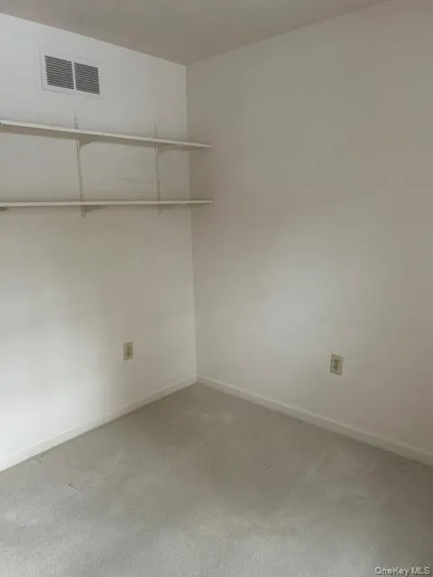 Empty room with carpet flooring and baseboards Empty room with carpet flooring and baseboards