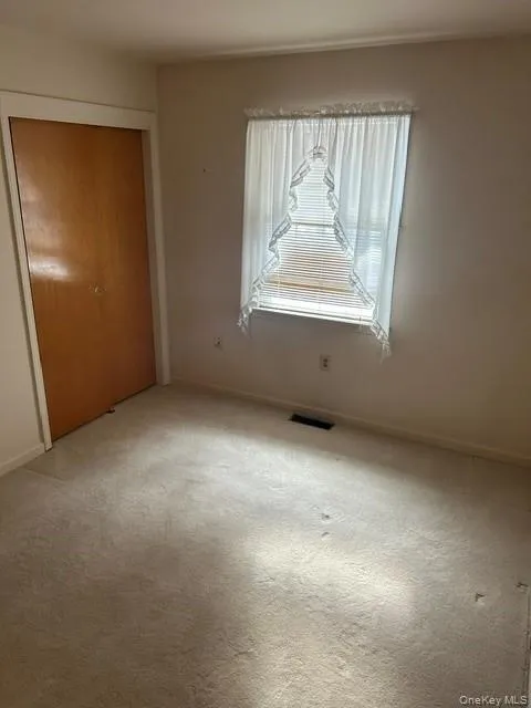 Unfurnished bedroom with a closet and carpet Unfurnished bedroom with a closet and carpet