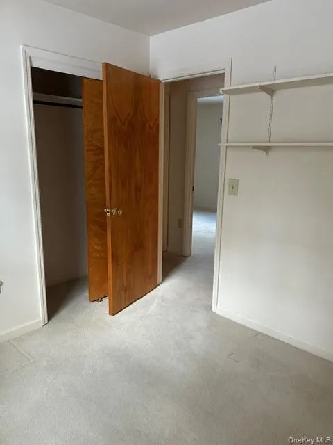 Unfurnished bedroom with light carpet and a closet Unfurnished bedroom with light carpet and a closet