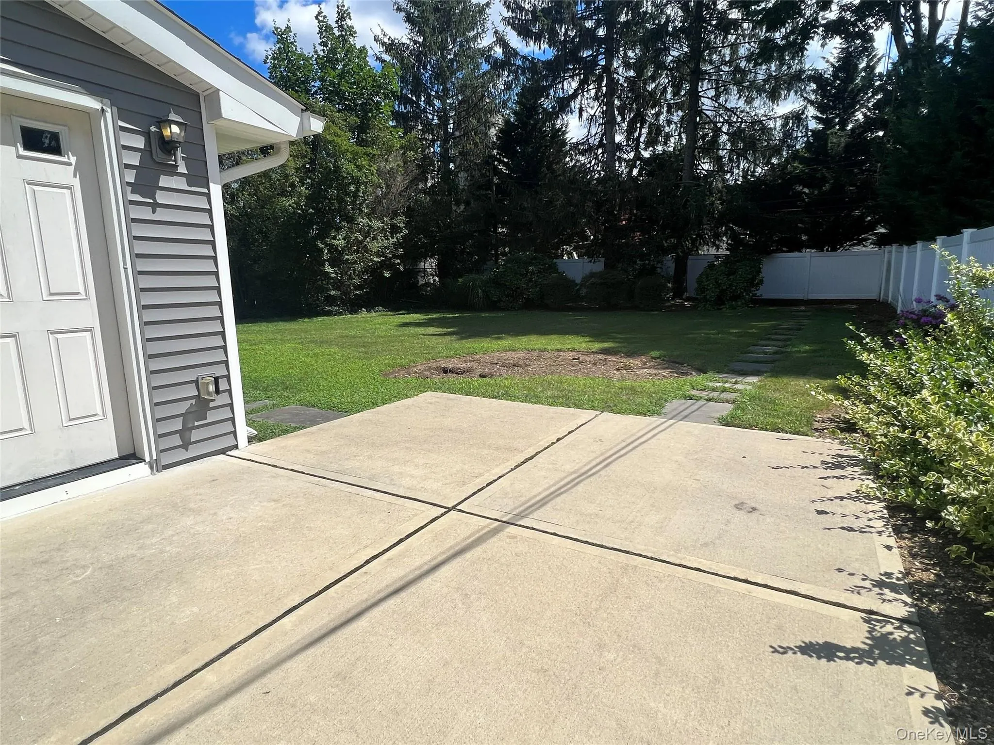 Fenced backyard with a patio area Fenced backyard with a patio area