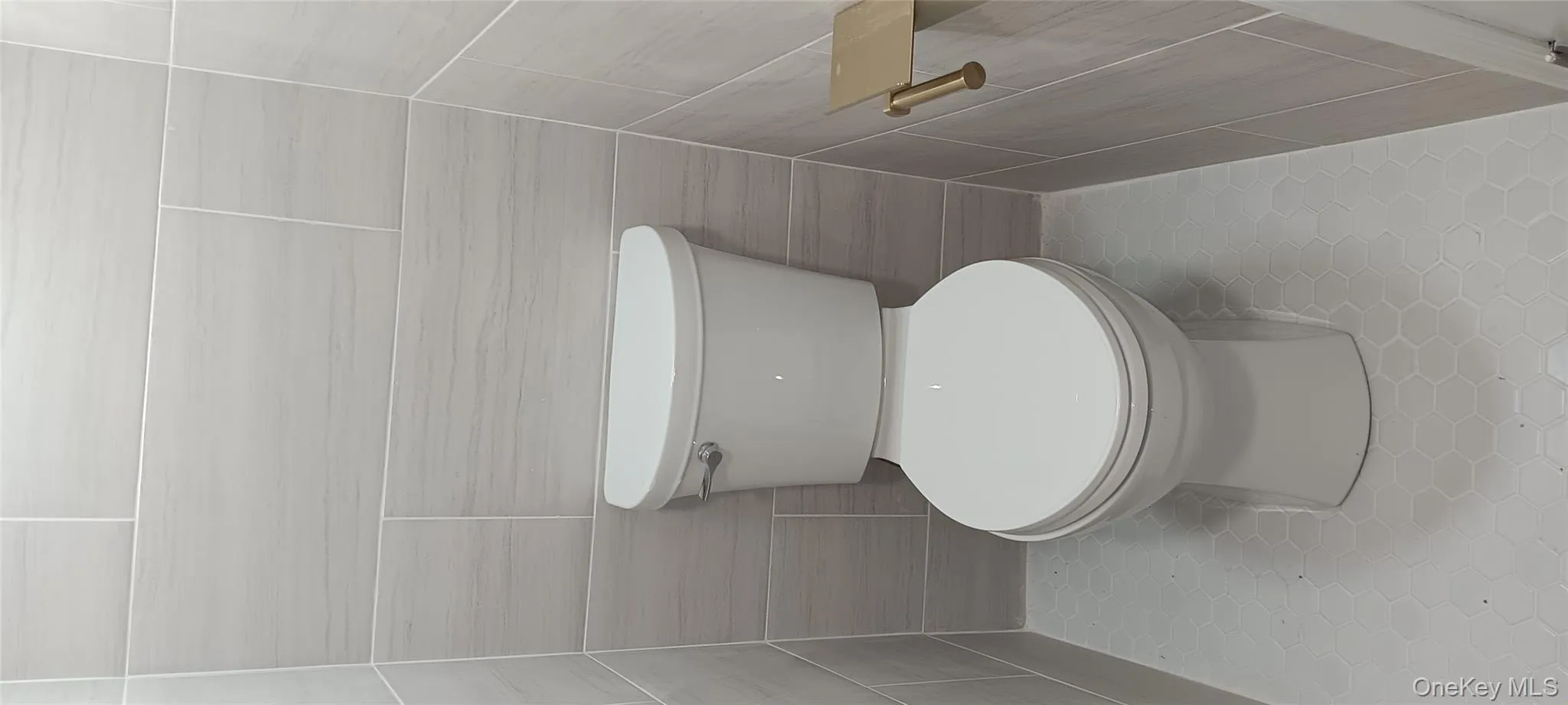 Bathroom featuring tile walls and light tile patterned floors Bathroom featuring tile walls and light tile patterned floors