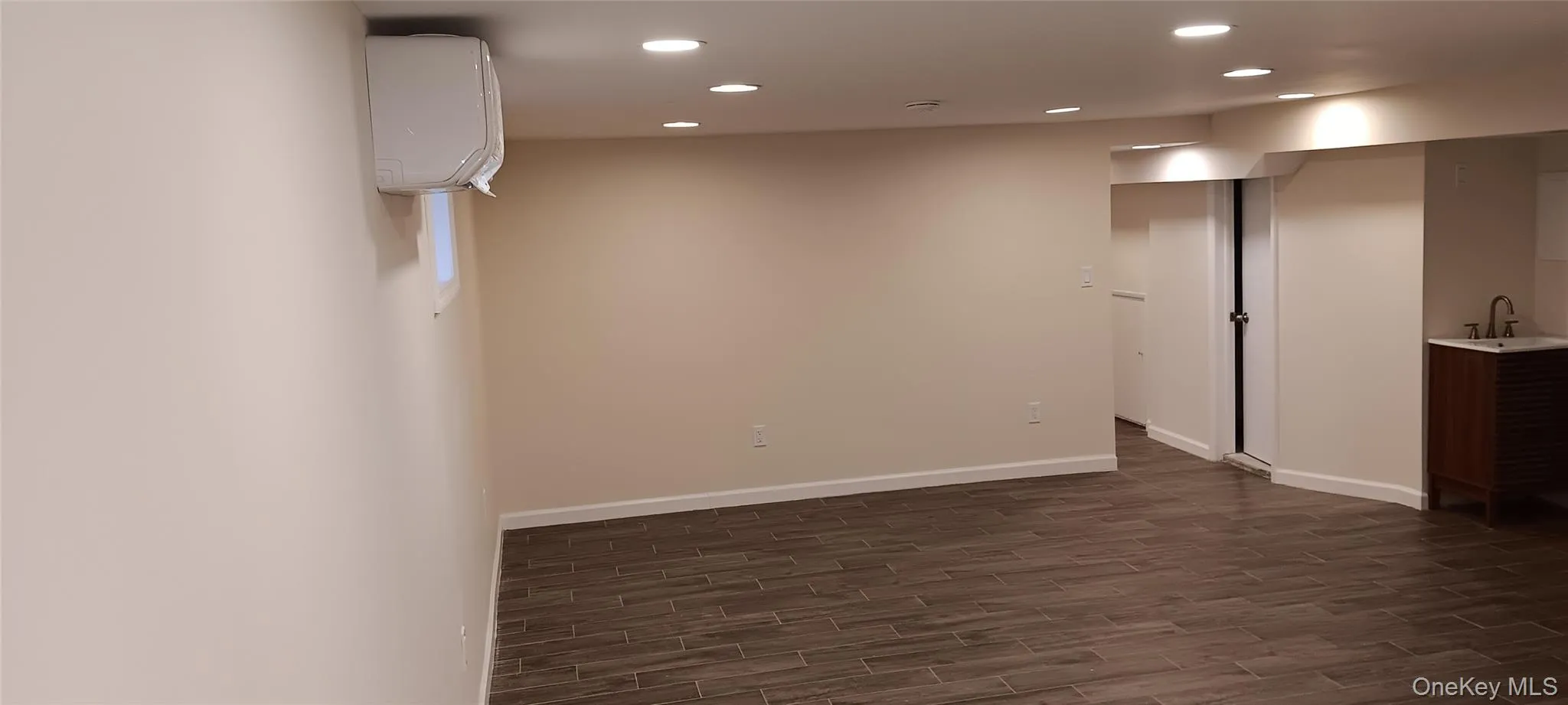 Unfurnished room with recessed lighting, wood finish floors, and a wall mounted AC Unfurnished room with recessed lighting, wood finish floors, and a wall mounted AC