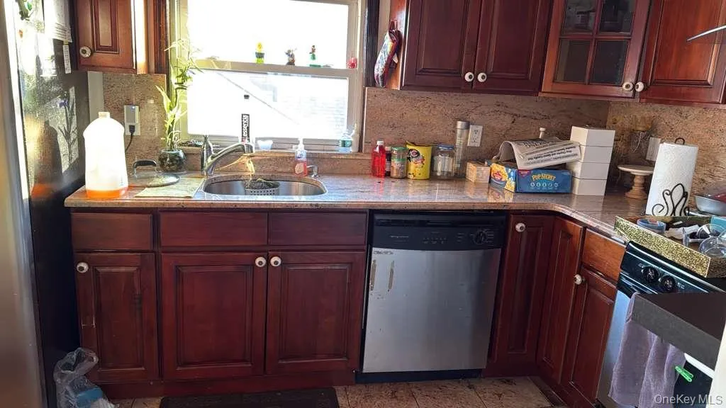 Kitchen with glass insert cabinets, appliances with stainless steel finishes, and backsplash Kitchen with glass insert cabinets, appliances with stainless steel finishes, and backsplash