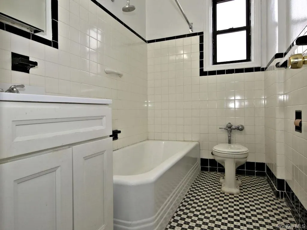 Bathroom with tile walls, shower / tub combination, and vanity Bathroom with tile walls, shower / tub combination, and vanity