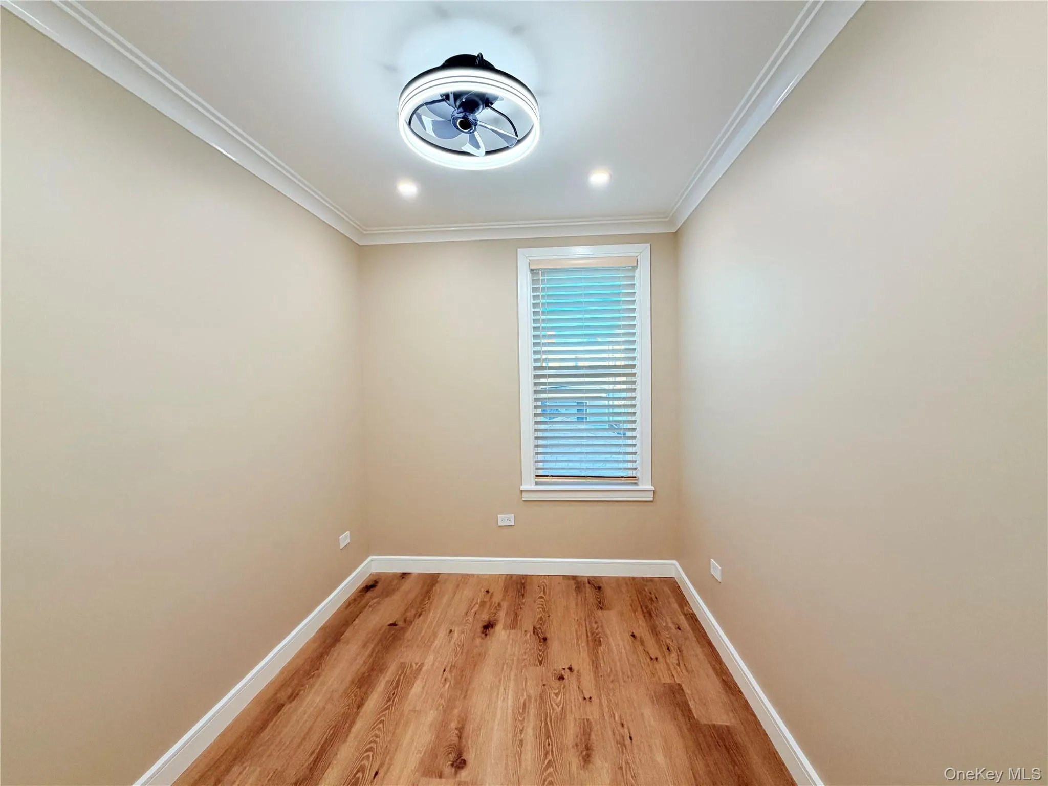 Empty room featuring ornamental molding, light wood-type flooring, and recessed lighting Empty room featuring ornamental molding, light wood-type flooring, and recessed lighting