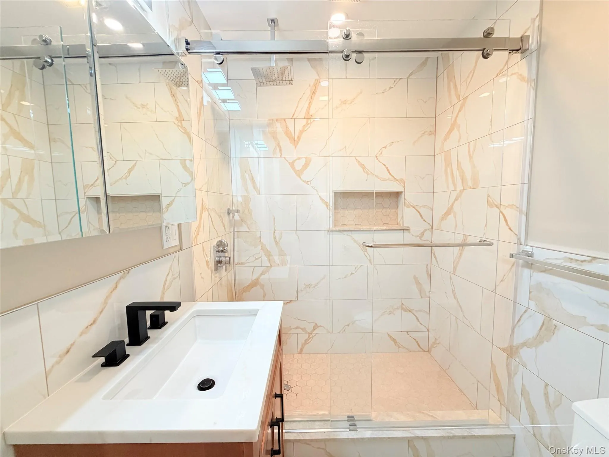 Bathroom featuring tile walls, vanity, and a stall shower Bathroom featuring tile walls, vanity, and a stall shower