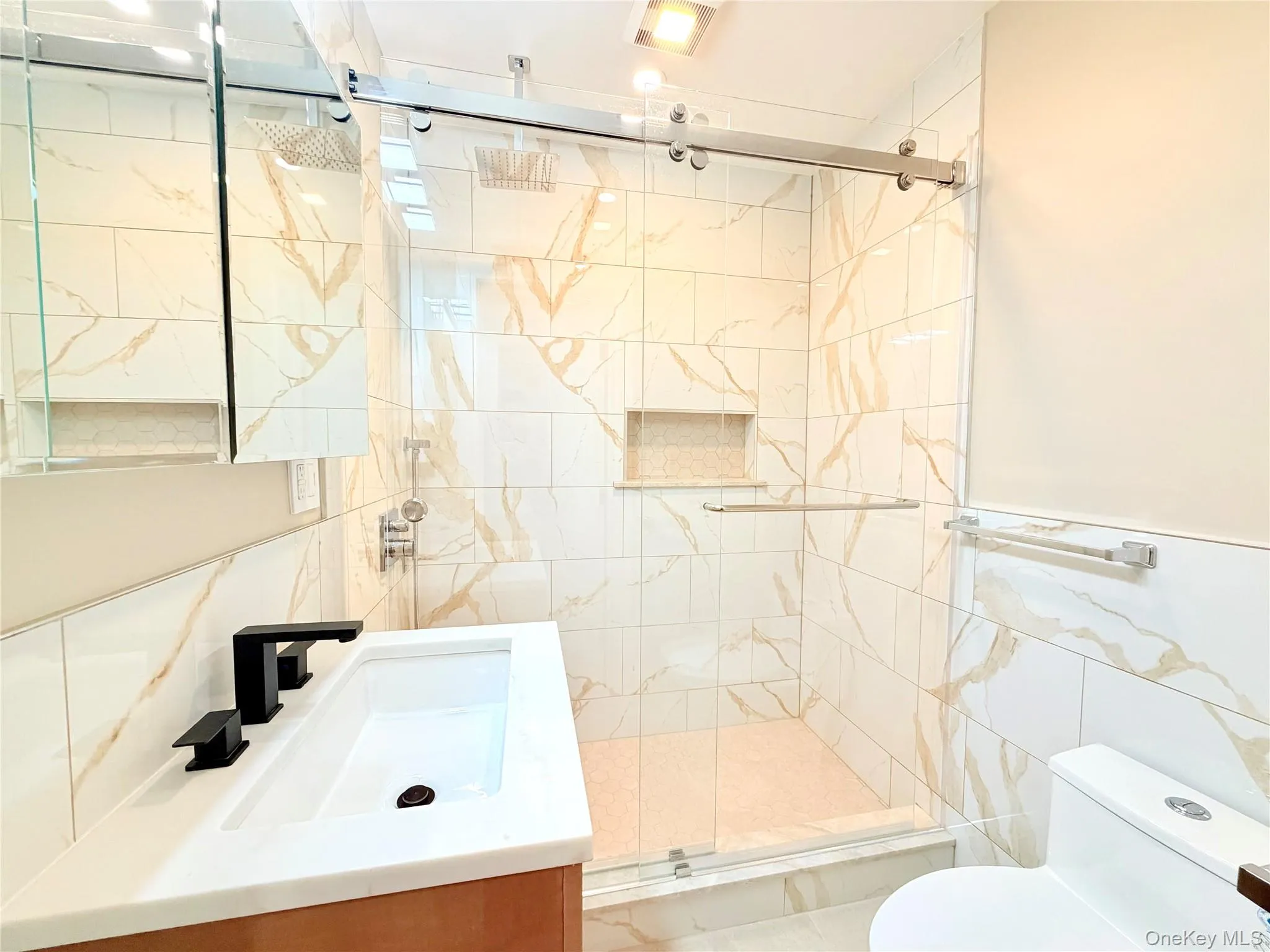 Bathroom with vanity, tile walls, a stall shower, and wainscoting Bathroom with vanity, tile walls, a stall shower, and wainscoting