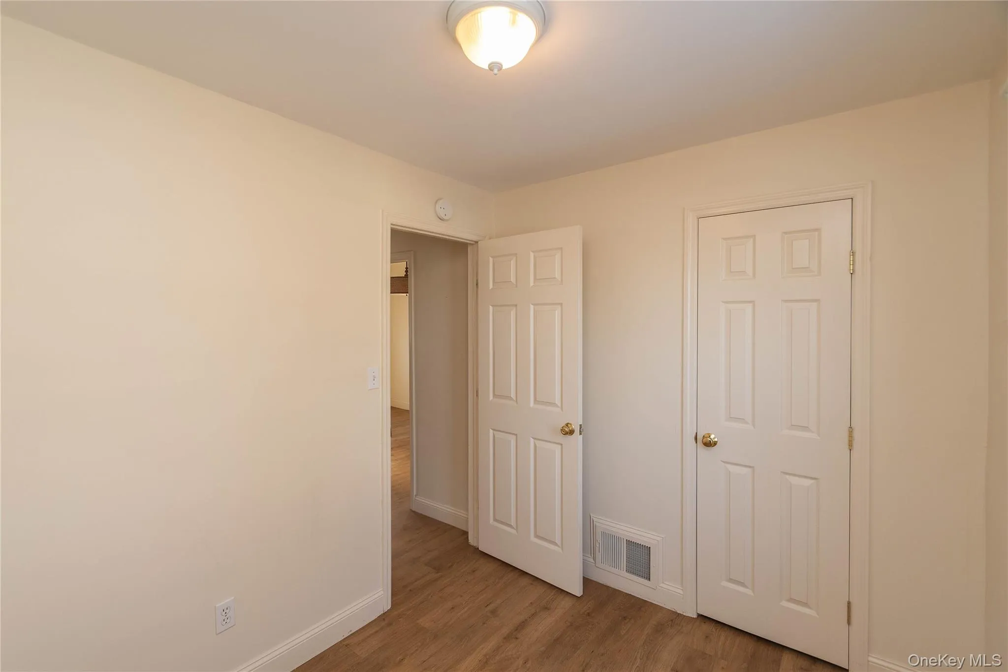 Unfurnished bedroom with light wood-type flooring and baseboards Unfurnished bedroom with light wood-type flooring and baseboards