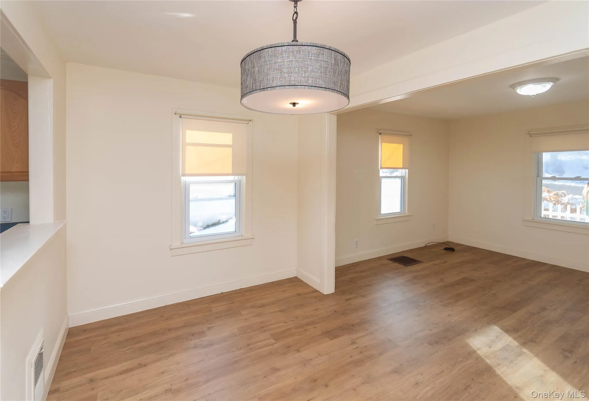 Unfurnished dining area featuring light wood-style flooring and baseboards Unfurnished dining area featuring light wood-style flooring and baseboards