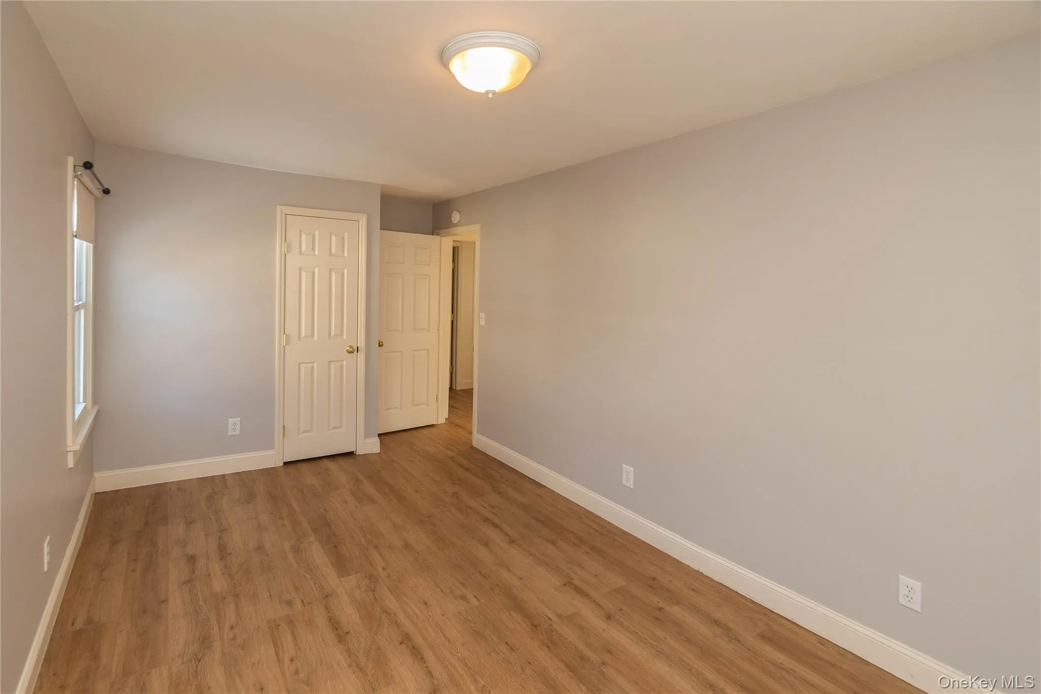 Unfurnished bedroom featuring wood finished floors and a closet Unfurnished bedroom featuring wood finished floors and a closet