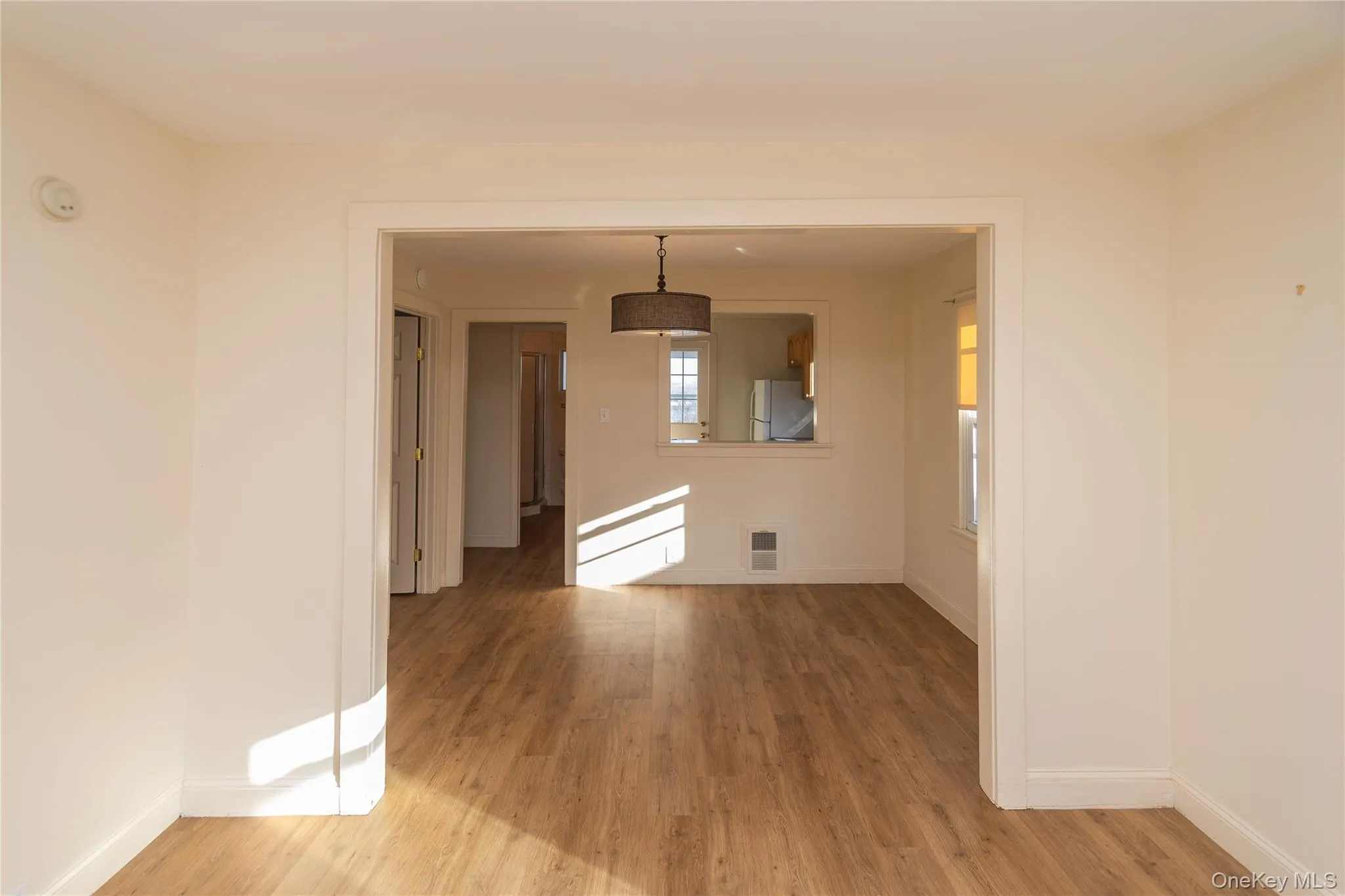 Unfurnished room with light wood-style floors and baseboards Unfurnished room with light wood-style floors and baseboards