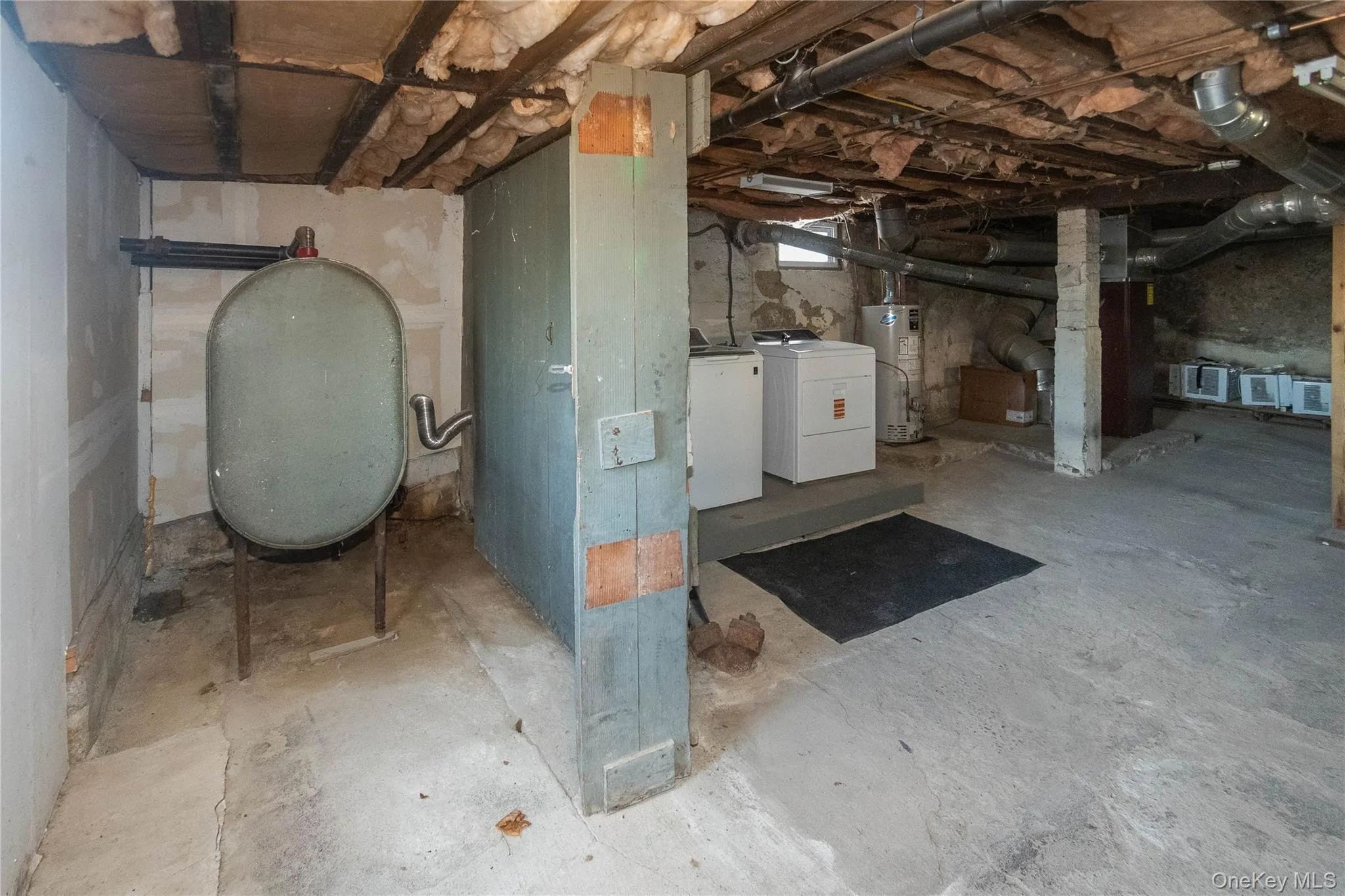 Unfinished below grade area featuring heating fuel, independent washer and dryer, and water heater Unfinished below grade area featuring heating fuel, independent washer and dryer, and water heater