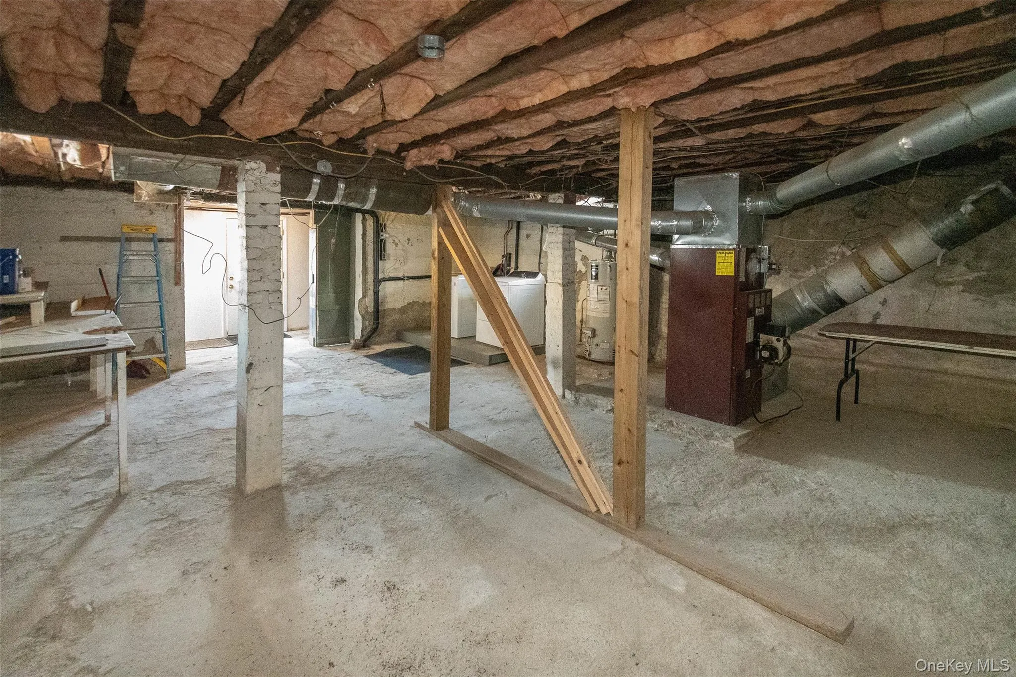 Unfinished basement with heating unit, washer / clothes dryer, and gas water heater Unfinished basement with heating unit, washer / clothes dryer, and gas water heater