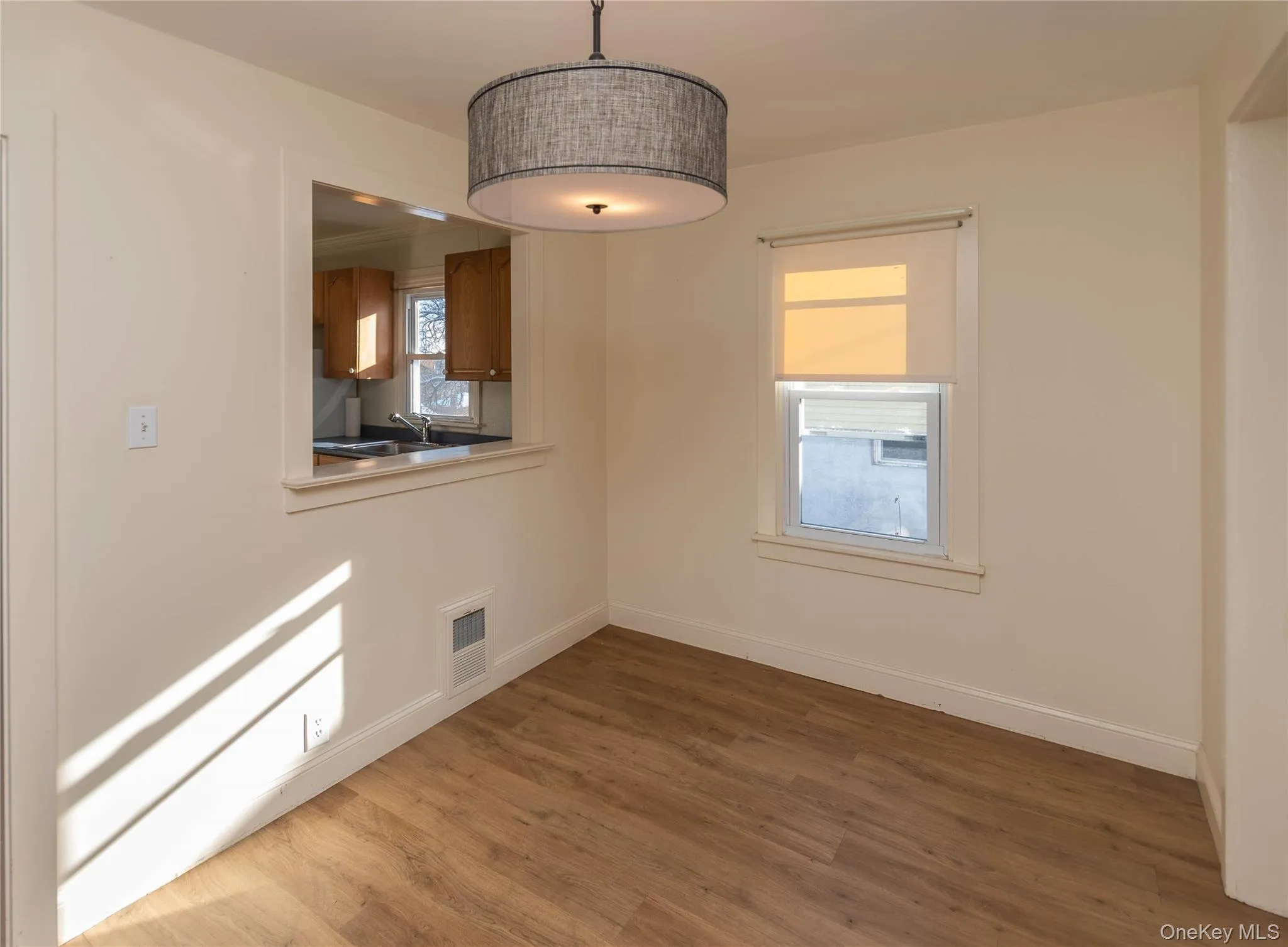 Unfurnished dining area with dark wood-style flooring and baseboards Unfurnished dining area with dark wood-style flooring and baseboards