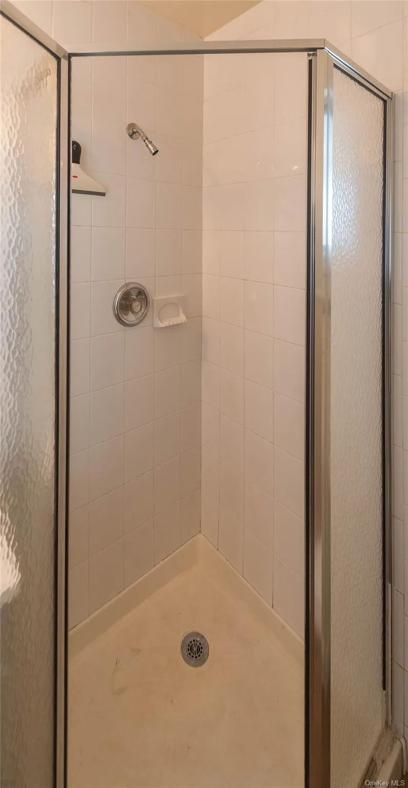 Full bath featuring a shower stall Full bath featuring a shower stall