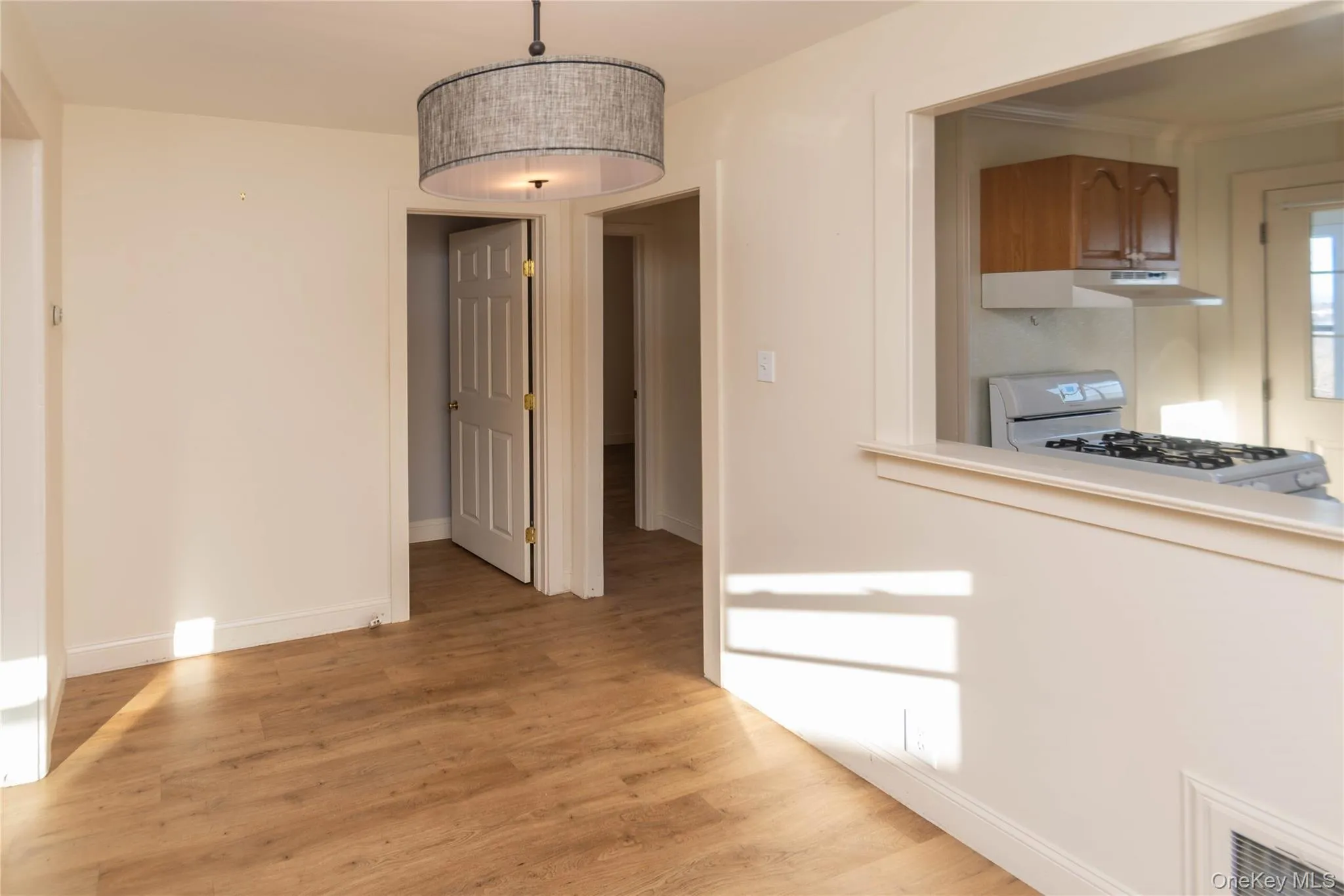 Unfurnished dining area with light wood-style flooring and baseboards Unfurnished dining area with light wood-style flooring and baseboards