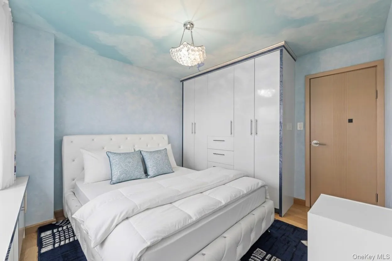 Bedroom featuring wood finished floors, a chandelier, and a closet Bedroom featuring wood finished floors, a chandelier, and a closet