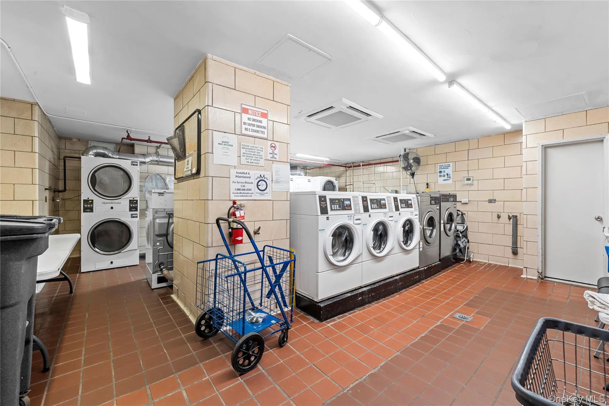 Community laundry featuring cooling unit, stacked washer / drying machine, and attic access Community laundry featuring cooling unit, stacked washer / drying machine, and attic access