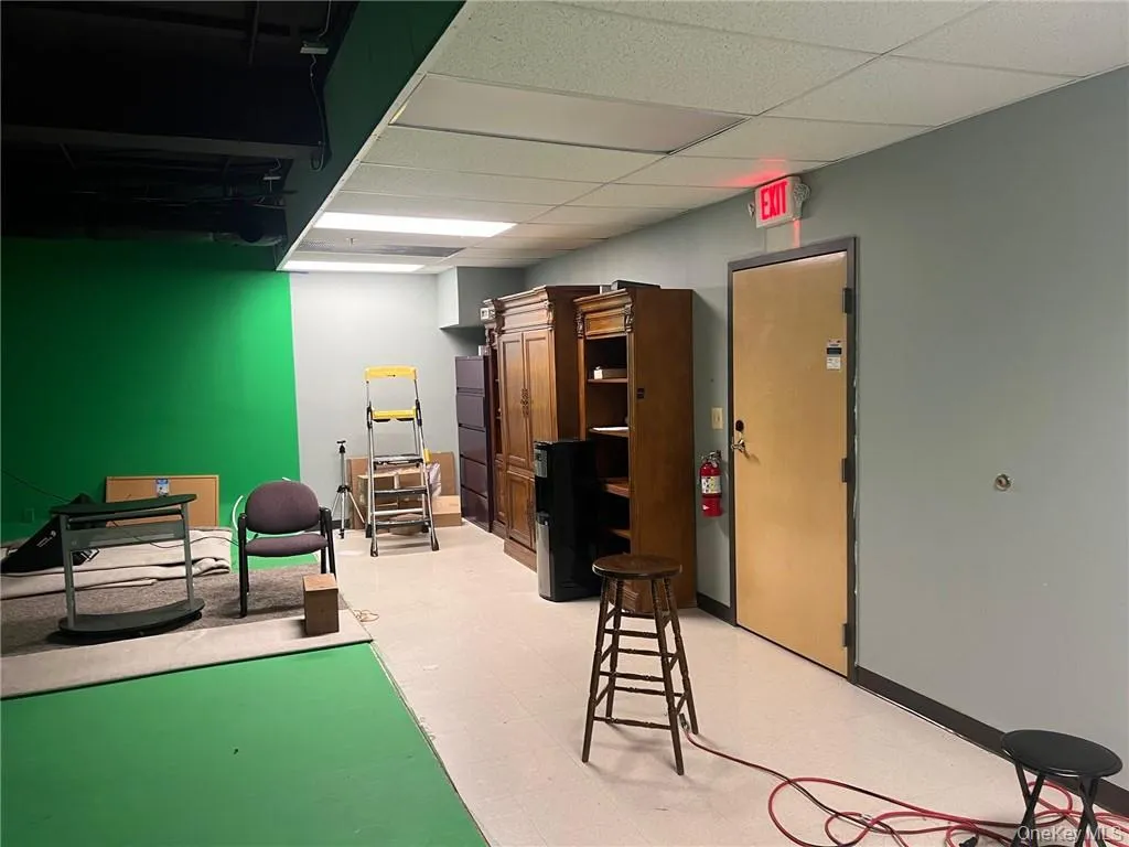 Office space featuring a black drop ceiling and green walls Office space featuring a black drop ceiling and green walls