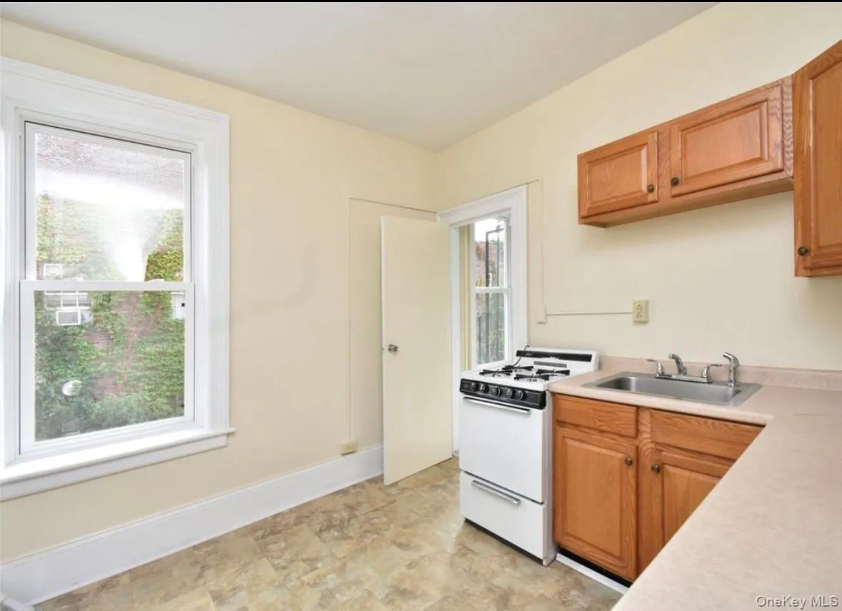Kitchen with gas range gas stove, light countertops, and brown cabinetry Kitchen with gas range gas stove, light countertops, and brown cabinetry