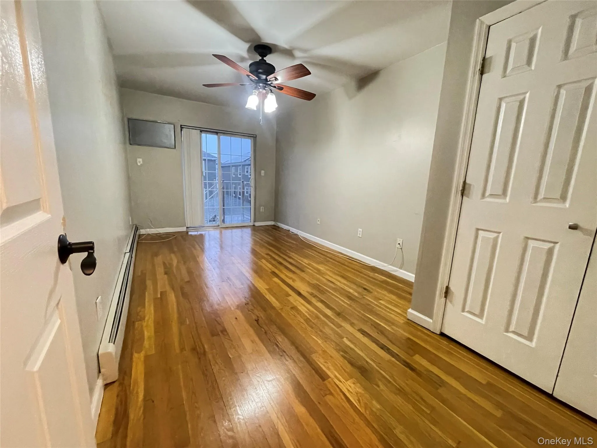 Unfurnished room featuring a baseboard radiator, light wood-style flooring, and ceiling fan Unfurnished room featuring a baseboard radiator, light wood-style flooring, and ceiling fan