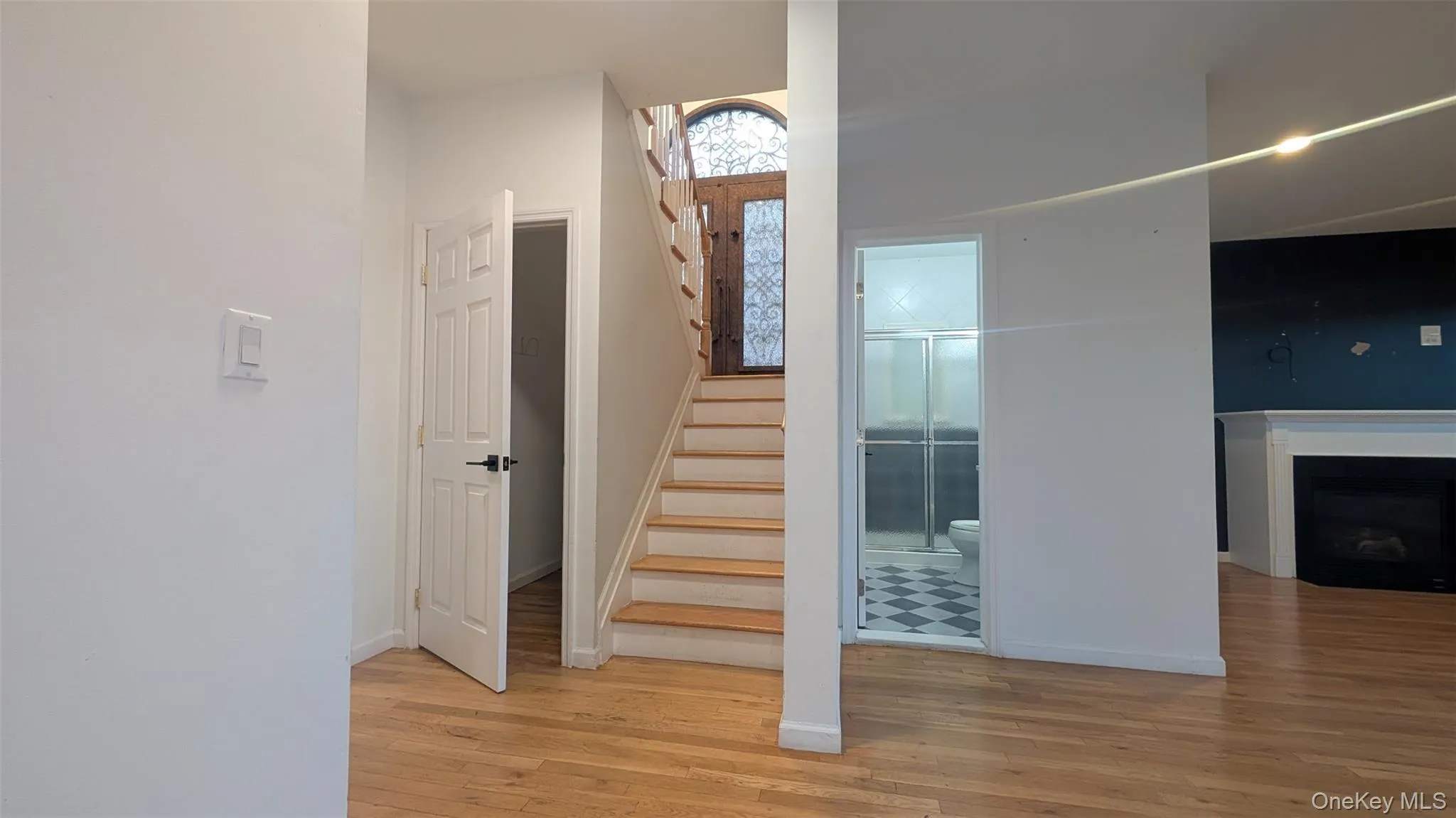 Staircase featuring hardwood / wood-style flooring and a fireplace Staircase featuring hardwood / wood-style flooring and a fireplace
