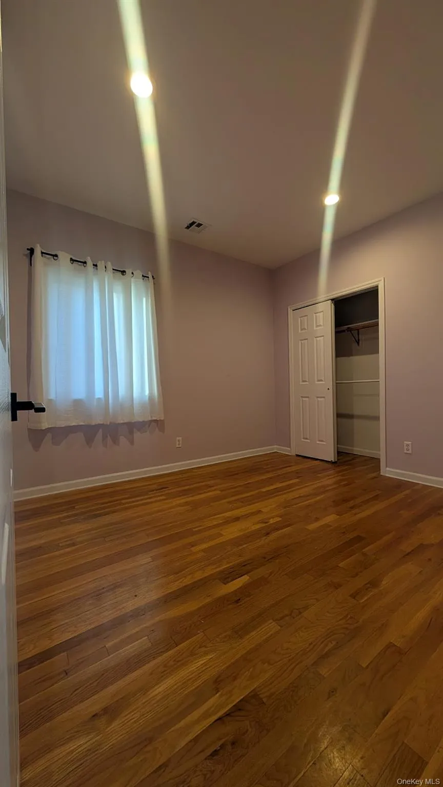Unfurnished bedroom with hardwood / wood-style flooring and a closet Unfurnished bedroom with hardwood / wood-style flooring and a closet