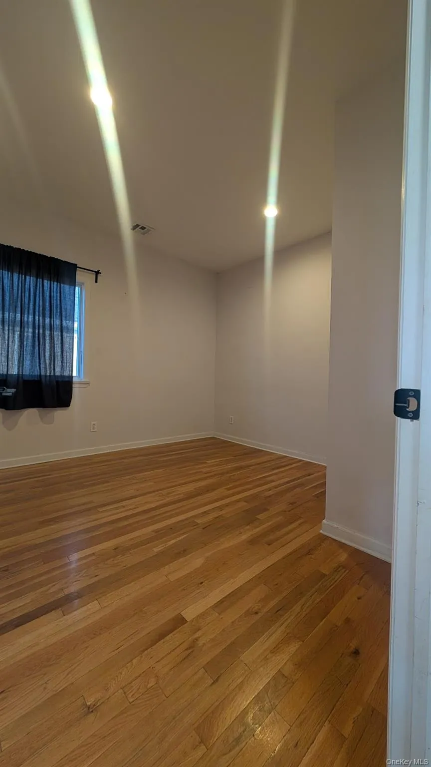 Spare room with light wood-style flooring and baseboards Spare room with light wood-style flooring and baseboards