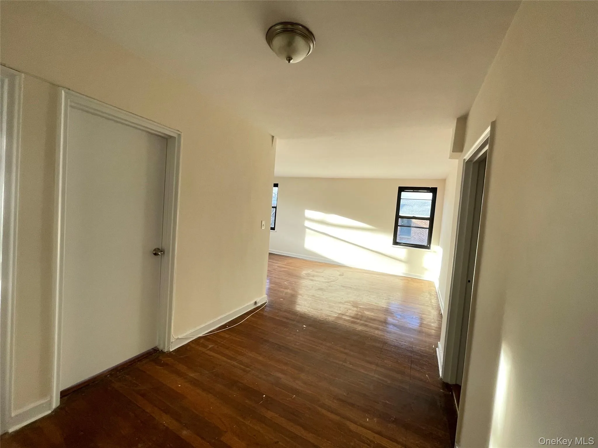 Corridor with dark wood-style flooring and baseboards Corridor with dark wood-style flooring and baseboards