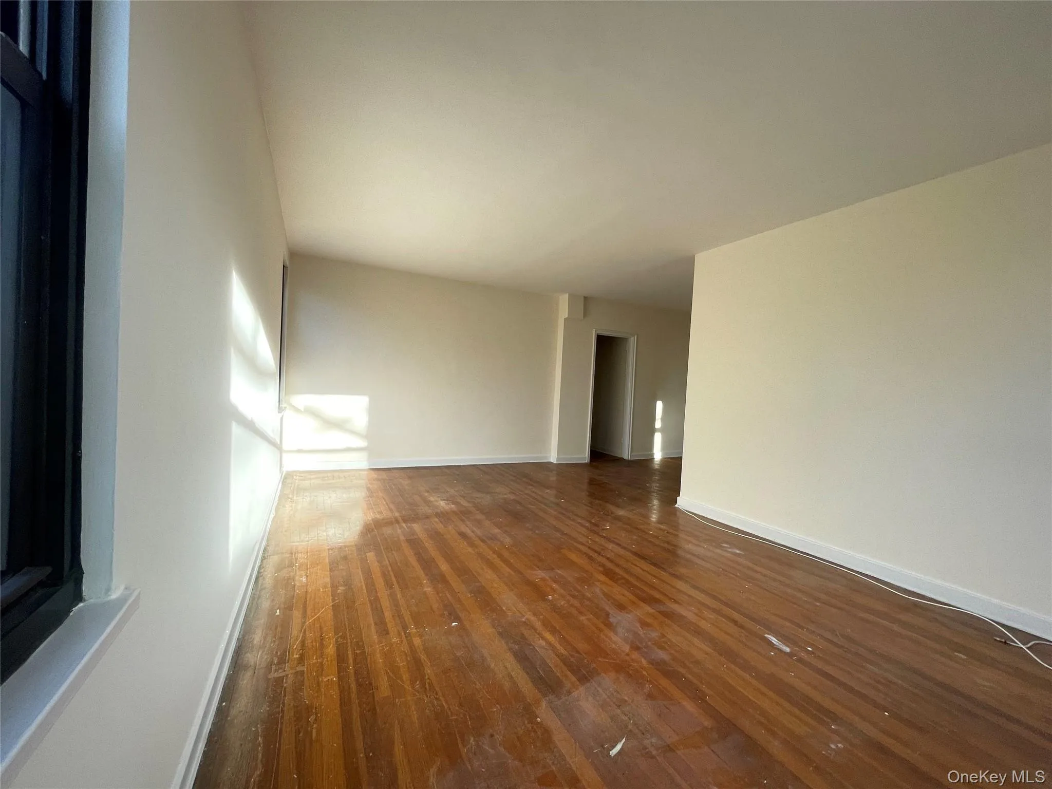 Empty room featuring dark wood-style flooring and baseboards Empty room featuring dark wood-style flooring and baseboards
