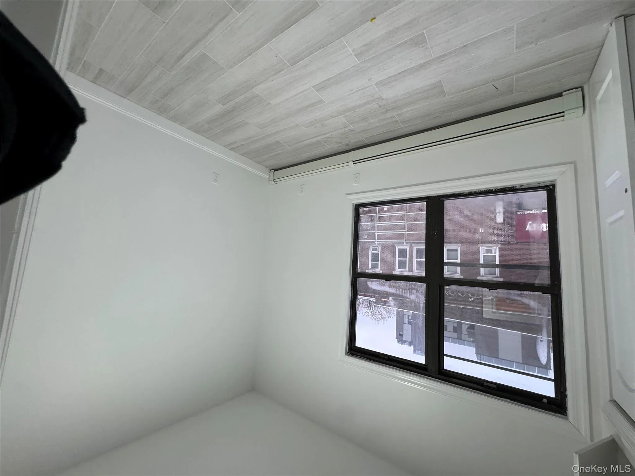 Unfurnished room featuring a baseboard radiator and wood finish floors Unfurnished room featuring a baseboard radiator and wood finish floors