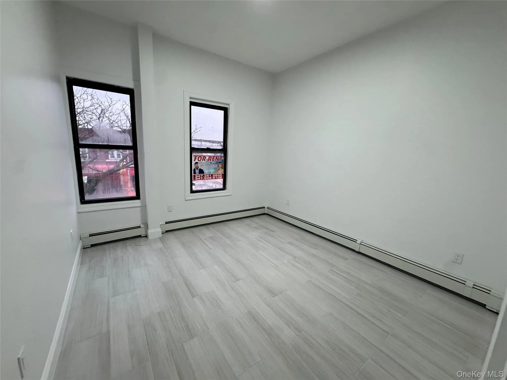 Unfurnished room with light wood-type flooring and a baseboard heating unit Unfurnished room with light wood-type flooring and a baseboard heating unit