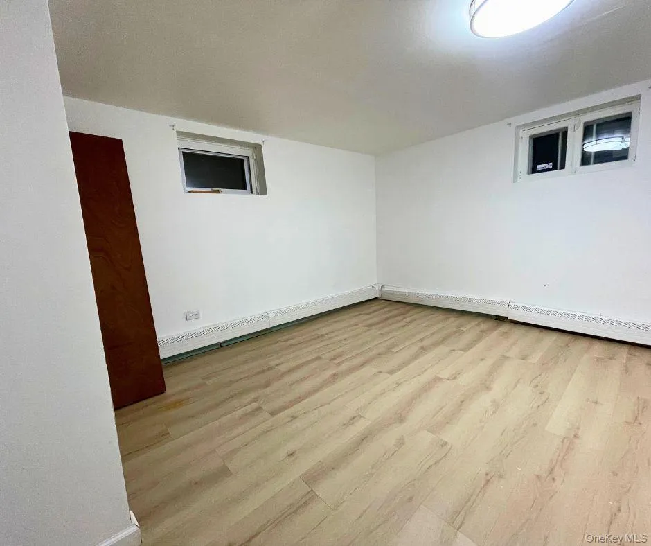 Spare room featuring light wood finished floors and a baseboard radiator Spare room featuring light wood finished floors and a baseboard radiator