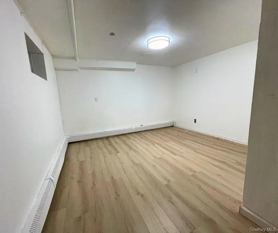 Spare room featuring light wood-style flooring and baseboard heating Spare room featuring light wood-style flooring and baseboard heating